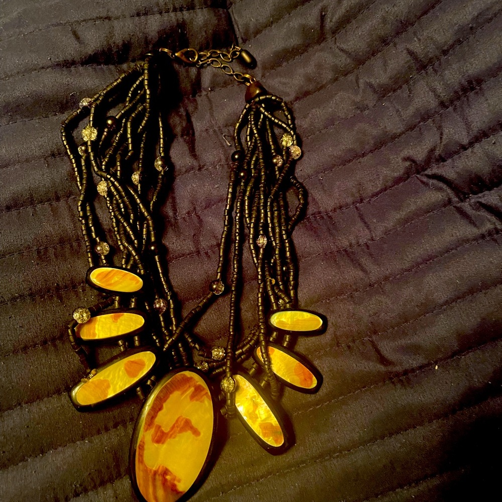 Black beaded necklace with black/tan design. Fits close to neck